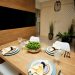 Contemporary dining area featuring a stylish wooden table set with elegant crockery and glassware.