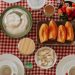 Vibrant breakfast spread featuring fresh fruits, pastries, and dairy on a checkered tablecloth.
